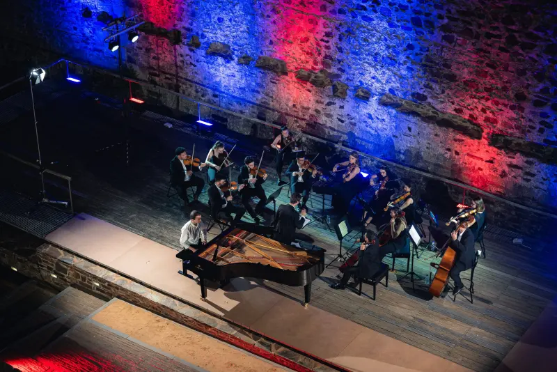 Francisco at the piano with a string orchestra under red and blue light, Castelo do Sabugal