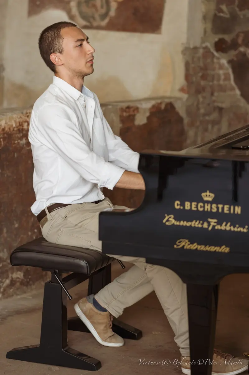 Francisco at a C. Bechstein grand piano in a room with bare stone walls