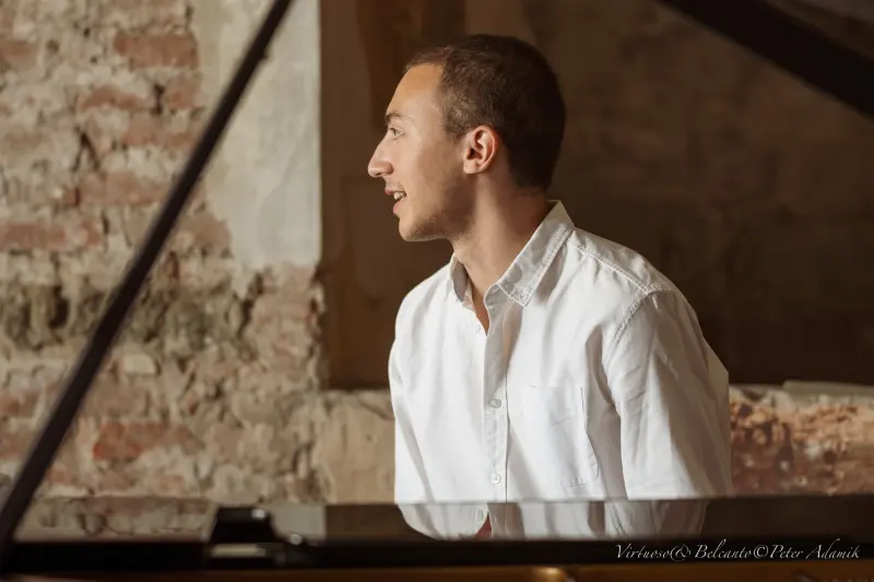 Francisco in profile at the piano, in a white shirt